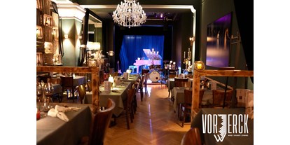 Eventlocations - Berlin-Stadt - Der Blick vom Podest zur Bühne, mit eingedeckten Tischen für einen Firmenevent. - Restaurant Vorwerck