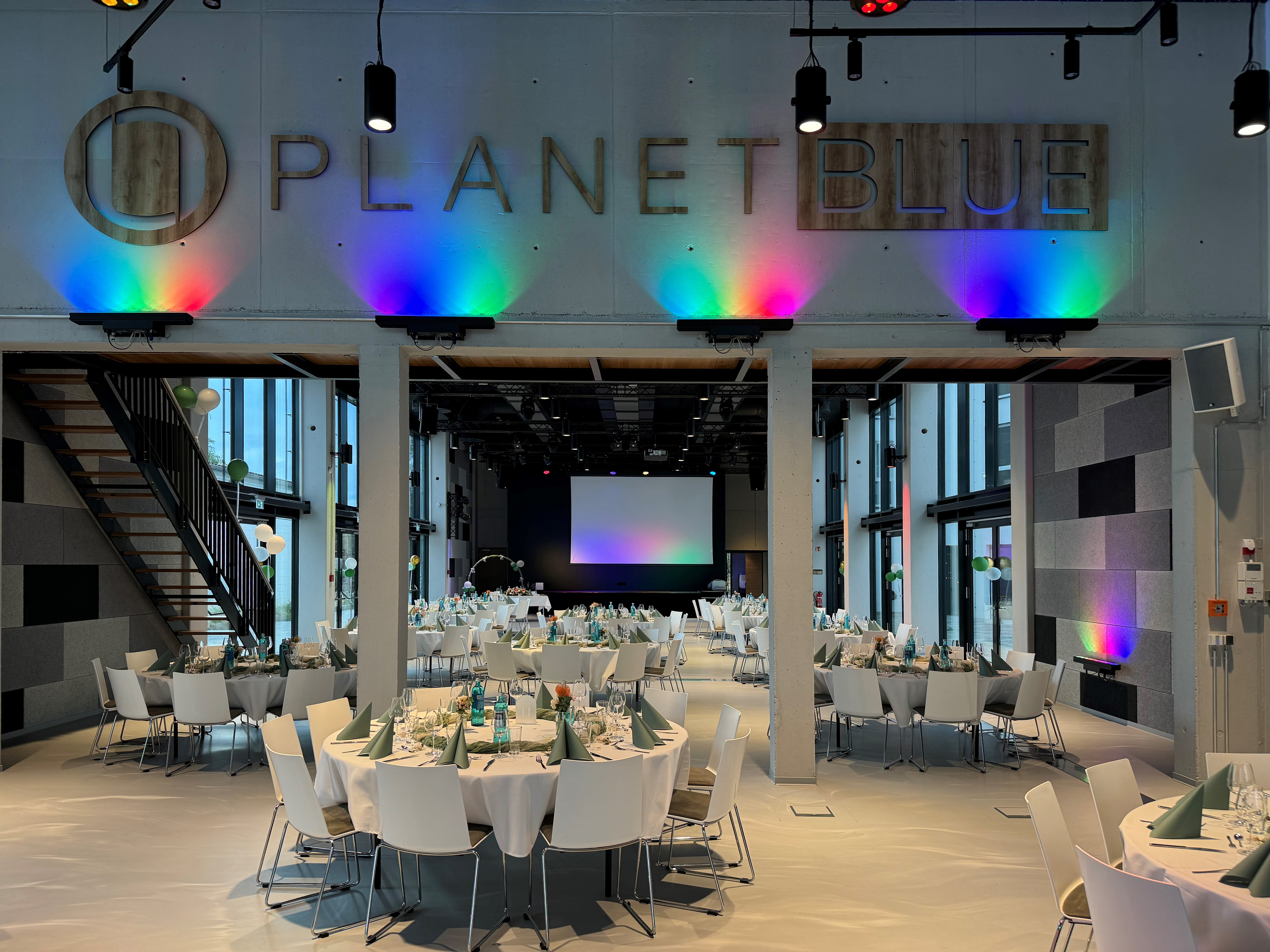 Eventlocation: Hochzeit im Veranstaltungssaal an Runden Tischen und festlicher Stimmung. Blick vom Foyer aus. - PLANET BLUE Eventlocation